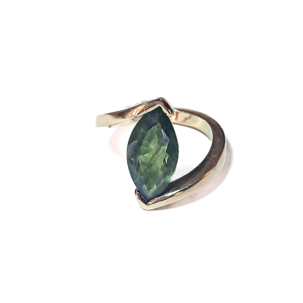 Gouden ring met grote saffier, ambachtelijk vervaardigd. Klemzetting met balans tussen vloeiende en strakke lijnen voor een tijdloos en elegant ontwerp.